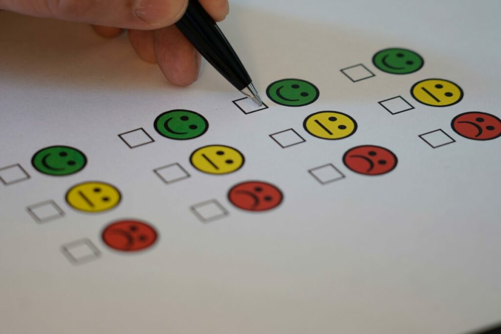 Picture of a checkmark options under emojis, smiling, sad and in between