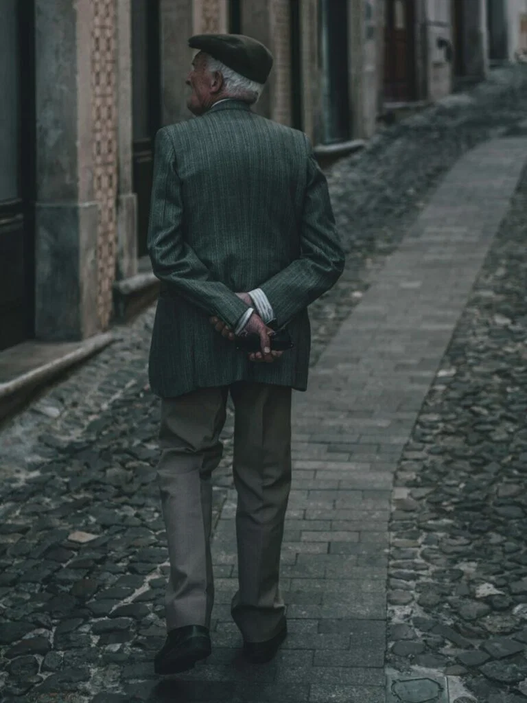 Photo of man from behind, with arms crossed behind his back