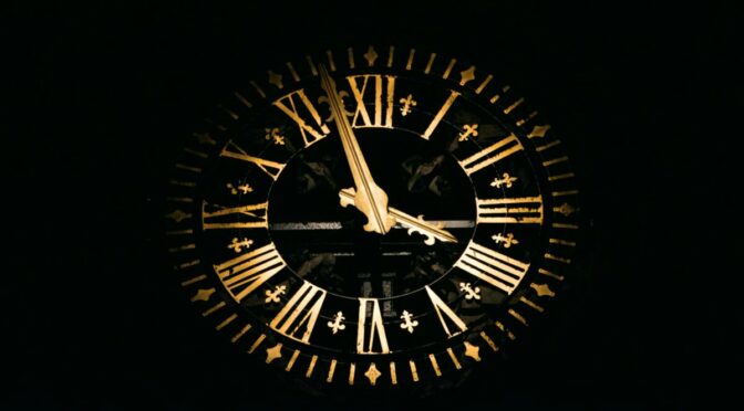 Photo of large clock face with gold numbers and hands